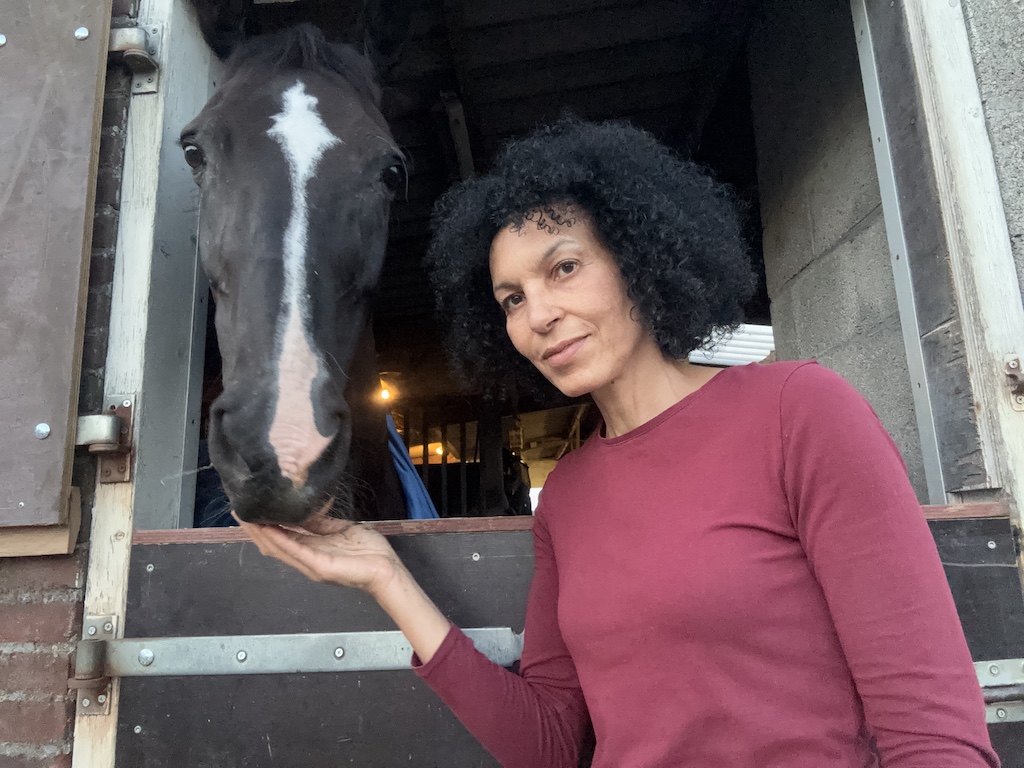 Paula Udondek houdt het hoofd van haar paard Ansa vast bij de stal in Leidschendam